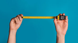 Person holding out a measuring tape